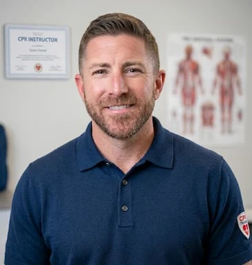 Will Cannon, owner and CPR instructor, smiling in medical office with instructor certificate on wall